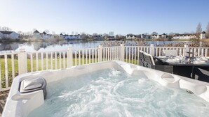 A hot tub with a view of a lake and houses in the background. - Windrush Lake 80/81, Waterlow Lodge (P) - Lakeside Lodge, Hot Tub, Sleeps 7 (South Cerney)