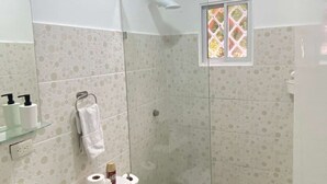 A bathroom with a toilet, sink, and shower area.