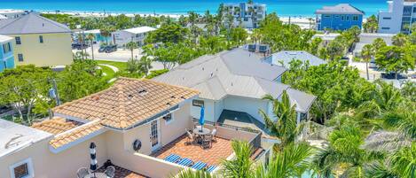 Zona residencial com piscina, um pátio com mobiliário de exterior e vista para o oceano.