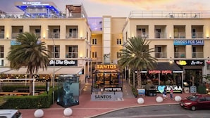 Une zone commerciale comprenant plusieurs boutiques, notamment « On The Rocks », « Santos Coffee with Soul », « Drunken Burger » et « Apurba ».