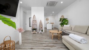 Un salon moderne avec un canapé, une table ronde et deux étagères décoratives.