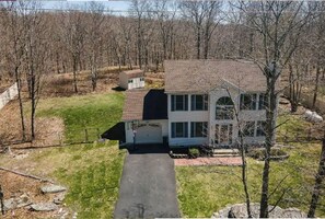 Set amidst a serene natural landscape, this two-story home offers a driveway and a garage.