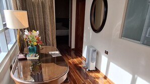 Ein Essbereich mit einem runden Tisch, Stühlen, einer Lampe und einem Blumenstrauß.