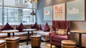 A modern lounge area with leather sofas, round tables, and pendant lighting. - Premier Inn Dublin Cc Gloucester St South (Dublin)