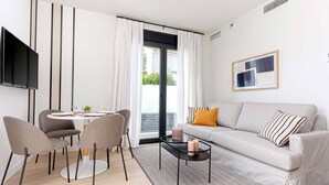 Un salon moderne comprenant un canapé, une table basse et un coin repas avec des chaises et une table.