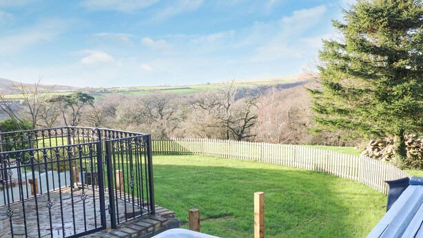 A hot tub with a view of a fenced yard and a grassy field. - Nant Moel Isaf Farm (Swansea)