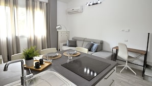 A modern kitchen with a central island, built-in sink, and a dining area with a table set for two. - Boutique Apartment "Divided Two" in Florence (Firenze)