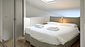 A modern bedroom with a large bed, a bedside lamp, and a skylight. - Boutique Apartment "Divided Two" in Florence (Firenze)