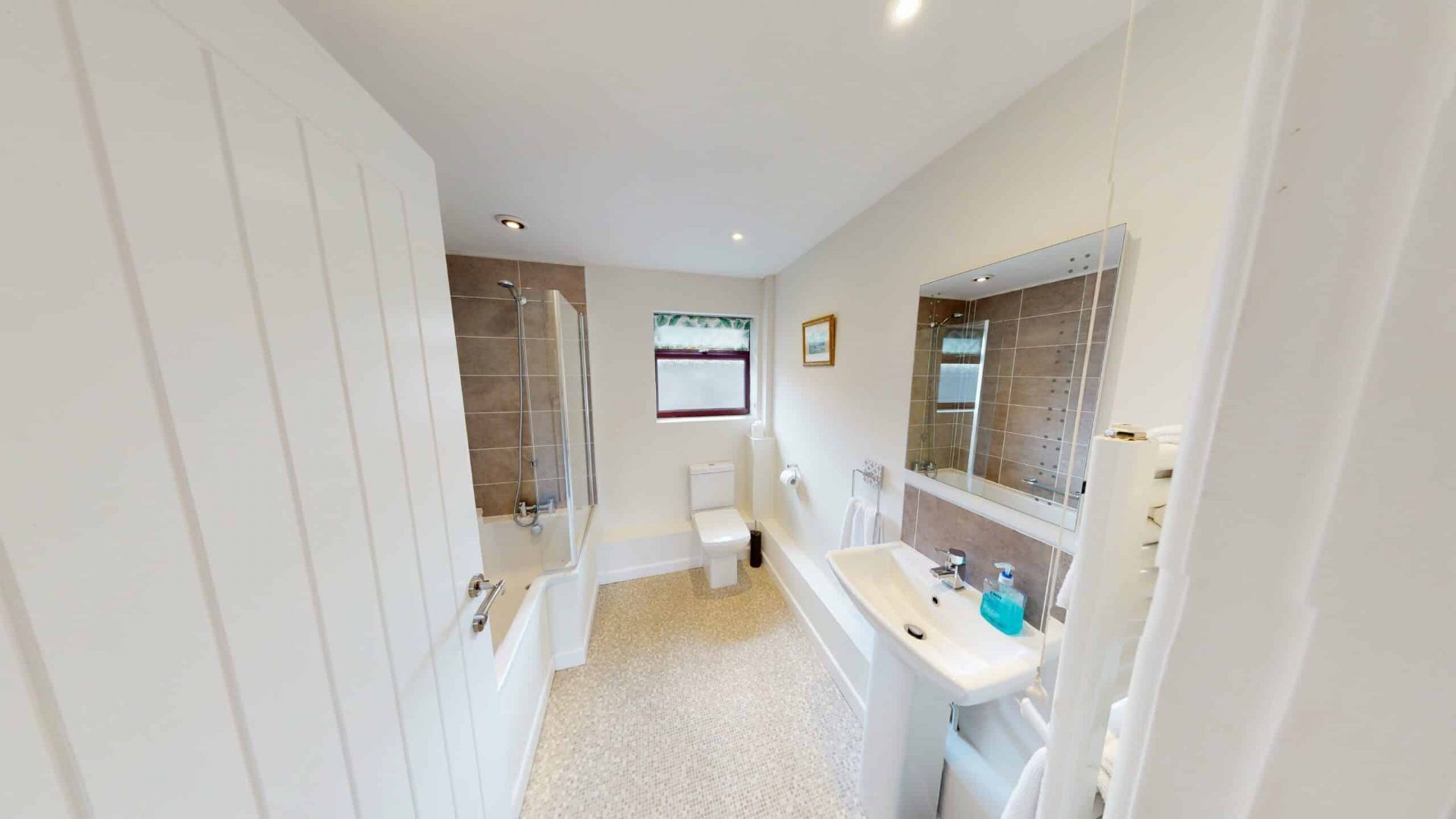 Een badkamer met toilet, douche, bad en wastafel.