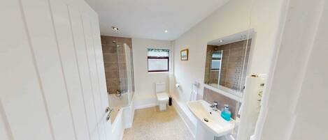 Een badkamer met toilet, douche, bad en wastafel.