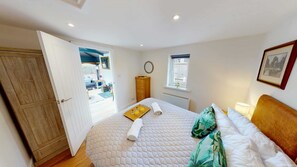 Une chambre à coucher avec un lit, une armoire en bois, une fenêtre et une vue sur l’extérieur.