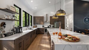 Una cucina moderna con una grande isola, mobili in legno e un piano di lavoro in marmo.