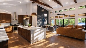 Un'ampia cucina con mobili in legno, un'isola grande e luci a sospensione.