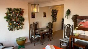 Zona pranzo con tavolo rotondo, sedie e lampadario.