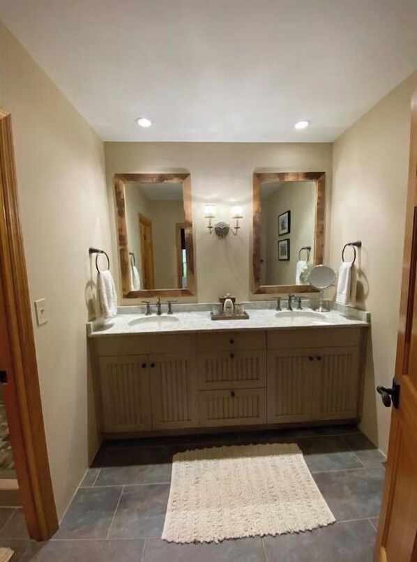 A bathroom with two sinks, a large mirror, and a wooden cabinet. - The Cabin at Denali Stud (Paris)