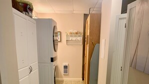 A narrow hallway with a washing machine, a small refrigerator, and a wooden door. - BlueRidgeVista.  4 miles to Tryon Equestrian Ctr. (Rutherfordton)