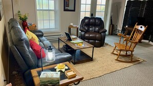 A living room with a leather sofa, a brown leather chair, a wooden rocking chair, a coffee table, and a laptop on a small table. - BlueRidgeVista.  4 miles to Tryon Equestrian Ctr. (Rutherfordton)
