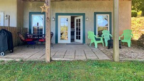 A covered patio with a table and chairs, a wooden post with a star ornament, and a door leading to a building. - BlueRidgeVista.  4 miles to Tryon Equestrian Ctr. (Rutherfordton)