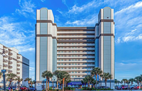 A modern hotel with a symmetrical facade, multiple floors, and a prominent Boardwalk sign.