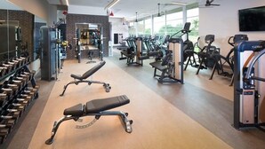 A modern gym with various exercise equipment, including treadmills, dumbbells, and weight machines. - Plano Tourist Hot Spot! (Plano)
