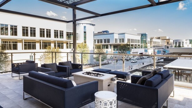 A rooftop terrace with modern outdoor seating, a fire pit, and a view of the cityscape. - Plano Tourist Hot Spot! (Plano)