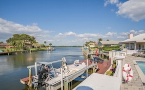 A marina with docked boats, a pool area with lounge chairs, and a waterfront view. - "Dive Into Fun! Spring & Summer Deals at Dolphin Cove – Walk to It All!" (Cocoa Beach)