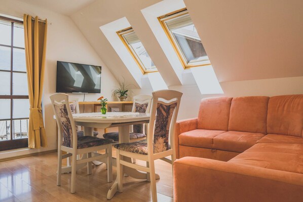Un espace repas comprenant une table, des chaises et un téléviseur.
