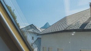 A view through a window with a clear sky and a mountain in the background.