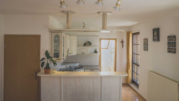 A kitchen with a central island, white cabinetry, and pendant lighting.