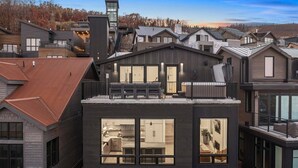 A modern residential building with a prominent kitchen area, large windows, and a balcony.
