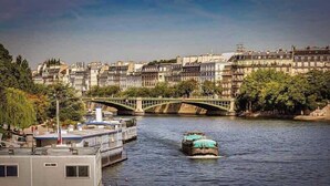 A river with a bridge, boats, and buildings along the riverbank. - 101 - Studio confortable avec kitchenette Paris 5 (Paris)