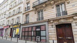 Une rangée de bâtiments avec des devantures de magasins, dont une affiche bien visible pour un café.