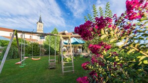 A backyard with a swing set, a ladder, and a hammock. - La Chambre Enchantée (La Baffe)