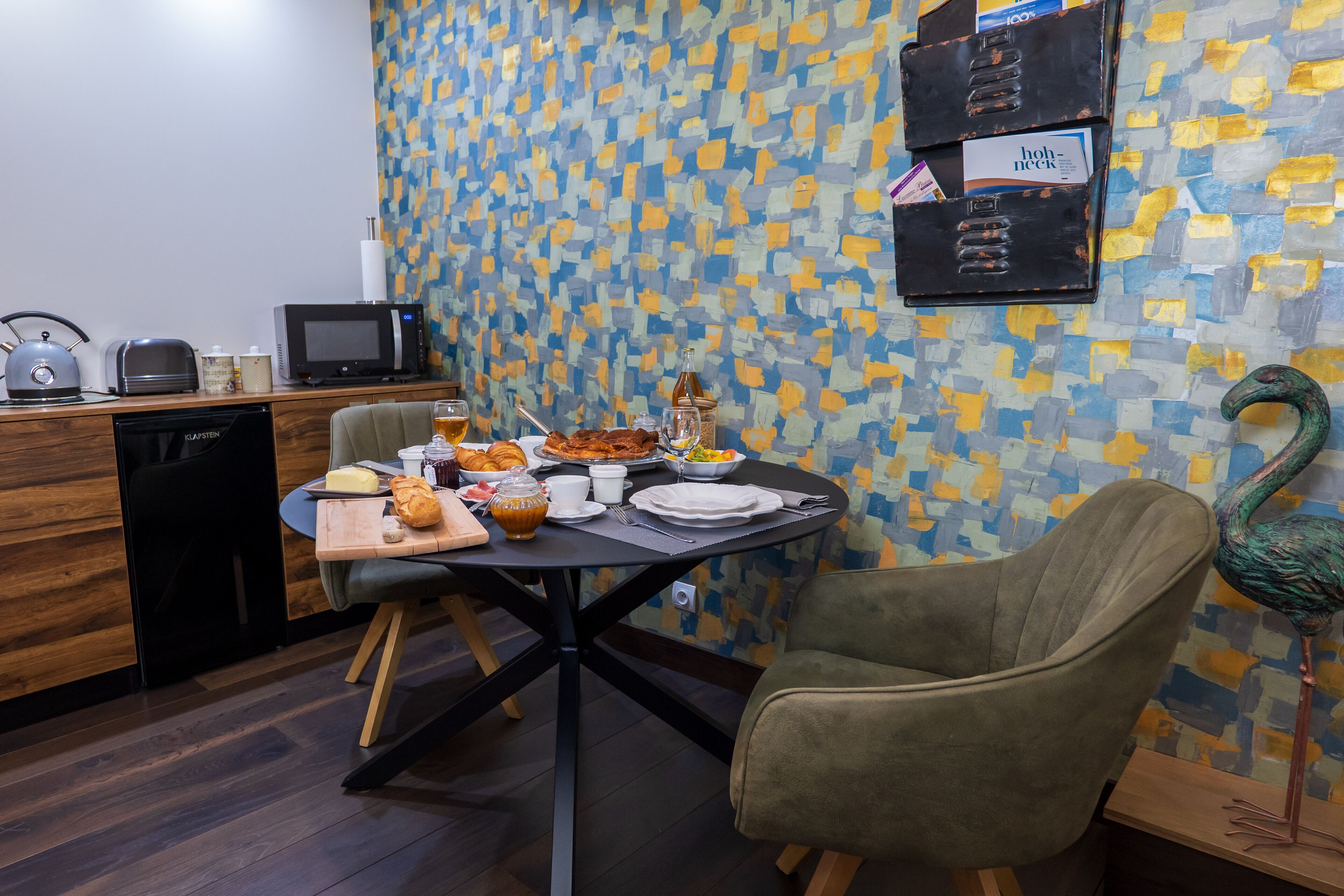 A dining area with a table set for breakfast, a microwave, a toaster, and a coffee machine.