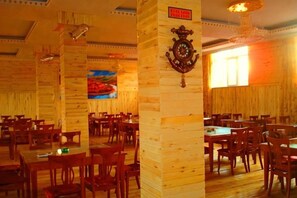 A restaurant with wooden walls and tables, a clock, and a painting. - Erguna, room, Wertley, Domiega resort (Ergun)