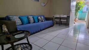 Un espacio de sala con un sofá, una mesita y dos sillas.