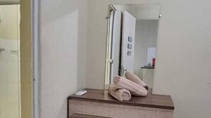 Una habitación con un aparador de madera, un espejo y una toalla encima.