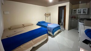 Una habitación con dos camas, una kitchenette y un baño.