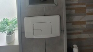 En vägg med en inbyggd hyllsektion som innehåller tre små skulpturer.