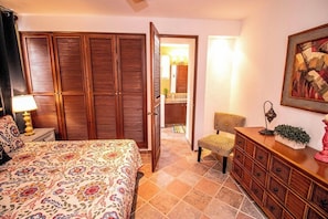 A bedroom with a bed, a dresser, a chair, and a wardrobe.
