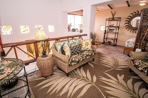 A furnished living room with a sofa, a round table, and a patterned rug.