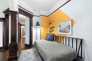 Cozy retreat with a large bed, wooden floor, and a stylish headboard.