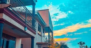 A multi-story building with a balcony and a staircase. - Nataaha Hotels (Mbarara)