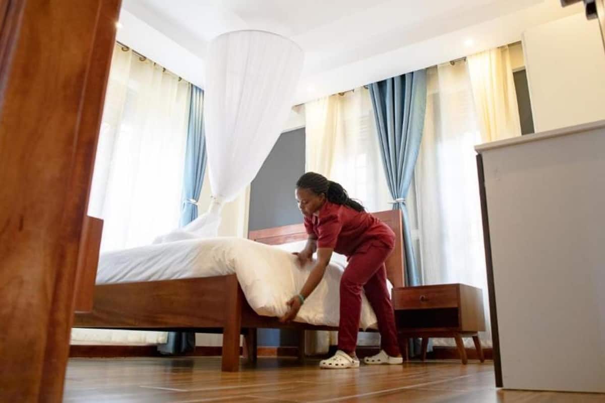 Un dormitorio con cama, mesita de noche, armario y dosel.