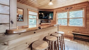 A wooden interior with a bar area, a television mounted on the wall, and a sign reading "Ski Lodge". - Spring & Summer Specials (Newry)