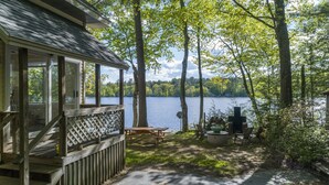 Un chalet au bord du lac, doté d’une terrasse, d’une table de pique-nique et d’un espace barbecue.