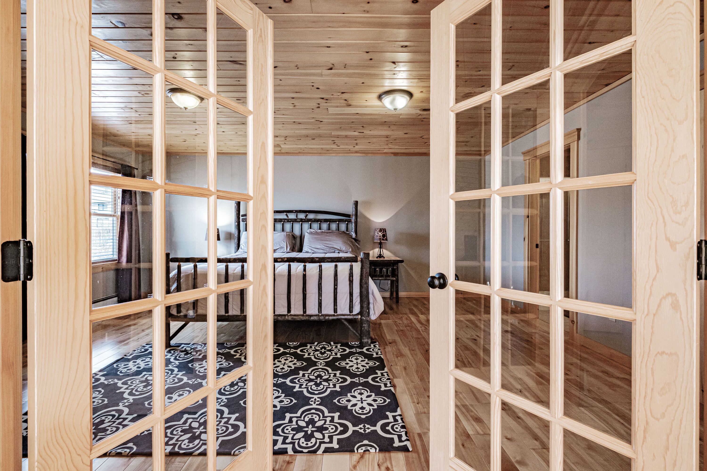 A room with a bed, a nightstand, and a patterned rug.