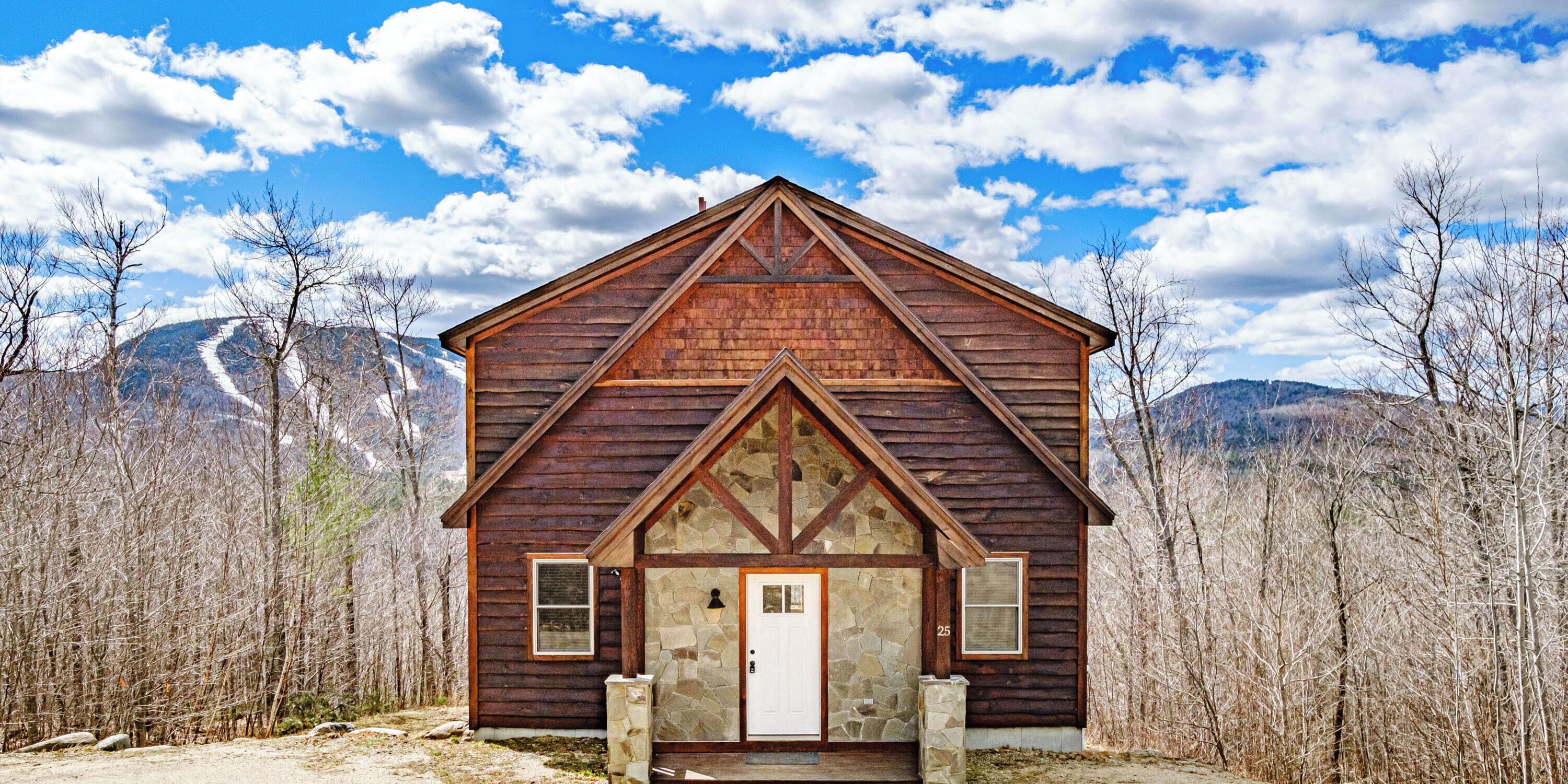 A wooden cabin with a stone foundation, located at 25 Blizzard Dr., Newry, ME.