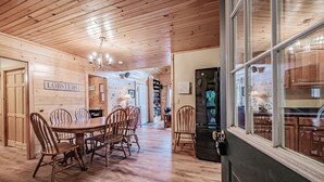 Un interno in legno con zona pranzo, tavolo e sedie, un lampadario e un cartello con scritto 'LOBSTERS'.