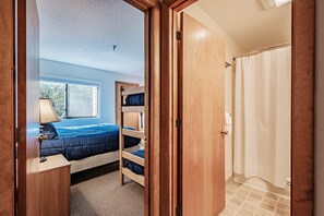 Une chambre avec un lit superposé, une fenêtre et un espace douche.